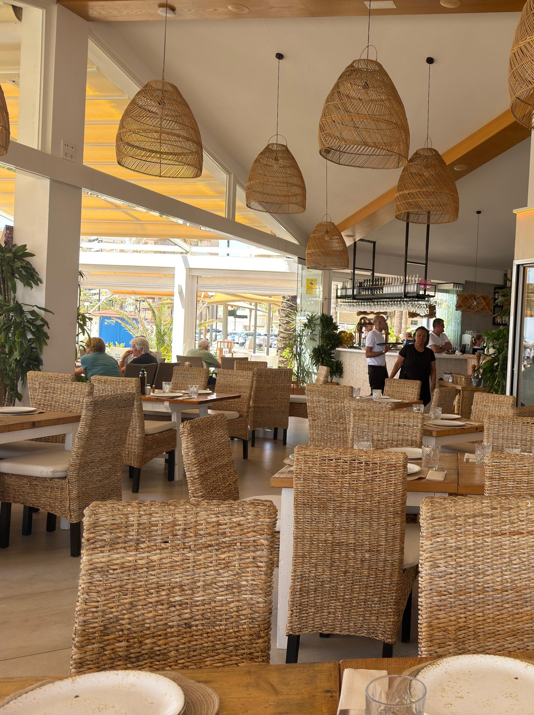 Interior renovado de Madrid Playa con techos de madera de roble y lámparas de ratán